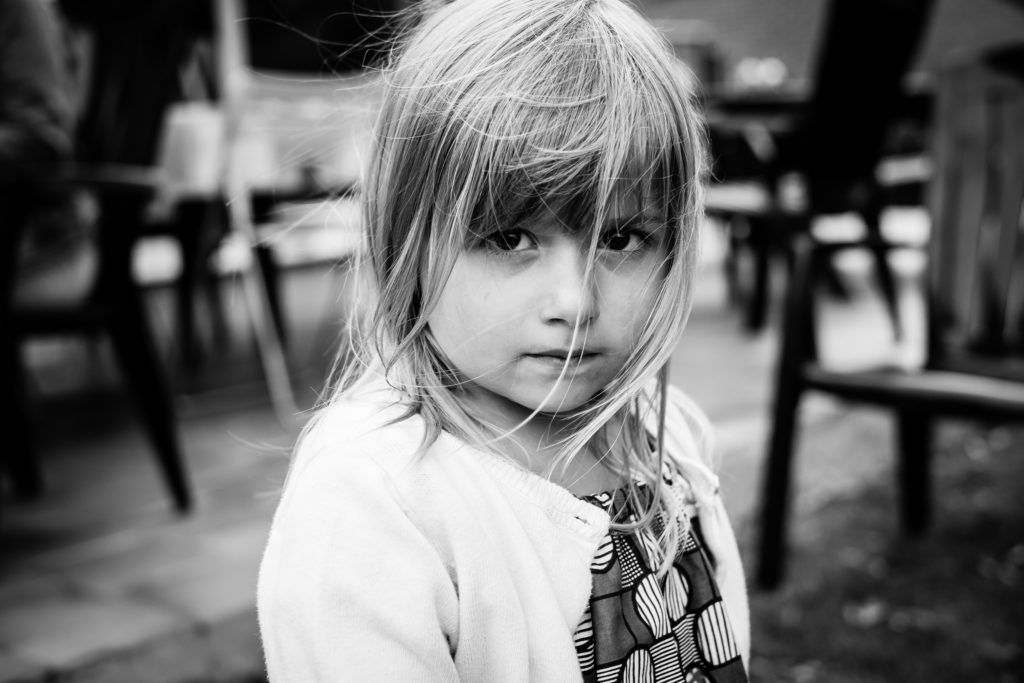 Photo en noir et blanc représentant un portrait serré d'une petite fille au regard intense