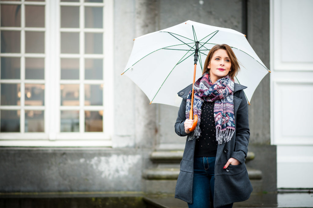 Photo en couleur, portrait d'une jeune femme sous son parapluie blanc