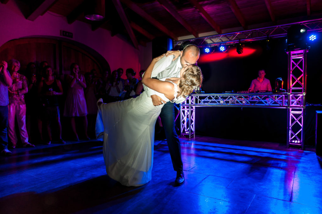 Photo couleur de la première danse des mariés éclairés par un flash et la lumière d'ambiance